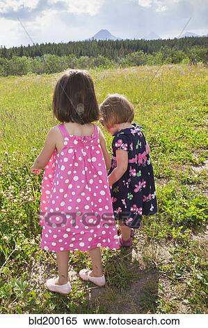 Stock Photography - Girls walking together in field. Fotosearch