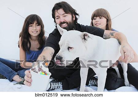 Girls watching father giving ice cream to dog View Large Photo Image Stock Photo - Girls watching father giving ice cream to dog. Fotosearch