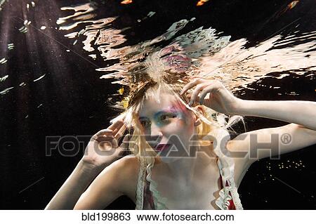 Stock Image - Glamorous Caucasian woman under water. Fotosearch