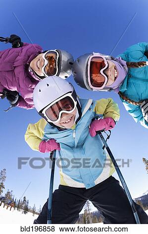 Stock Photo - Grinning family skiing together. Fotosearch