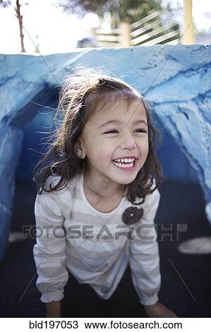 Stock Image - Grinning mixed race girl crawling. Fotosearch