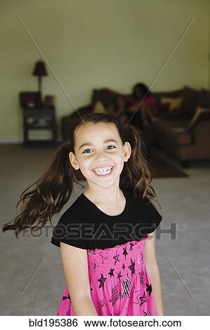 Grinning mixed race girl in living room View Large Photo Image Stock Photograph - Grinning mixed race girl in living room. Fotosearch