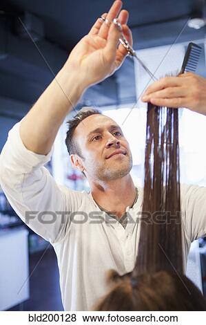 Stock Photo - Hairdresser cutting hair in salon. Fotosearch