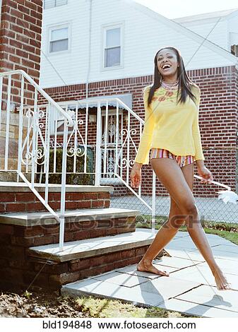Stock Photo - Happy barefoot woman near front stoop. Fotosearch