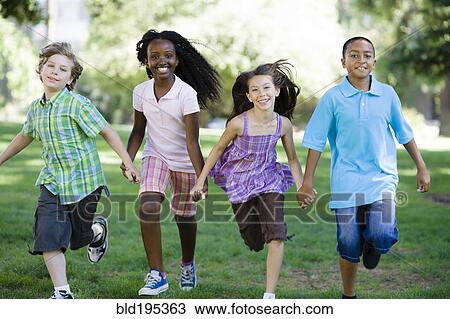 Stock Image - Happy children holding hands and running in park. Fotosearch