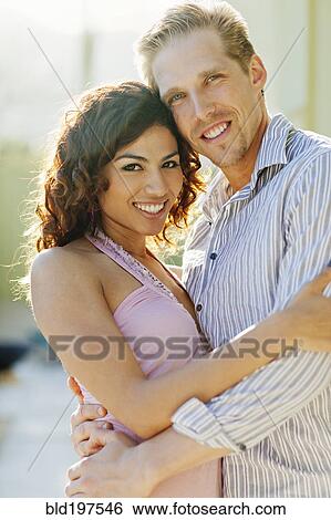 Stock Photograph - Happy couple hugging outdoors. Fotosearch