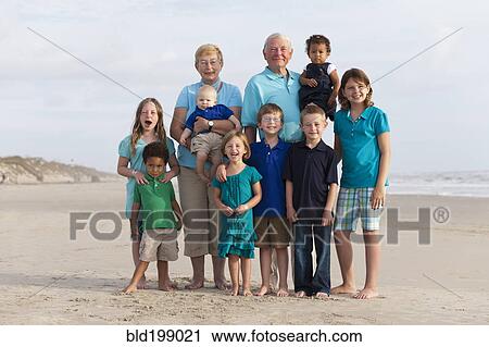 Stock Image - Happy multi-generation family enjoying beach together. Fotosearch