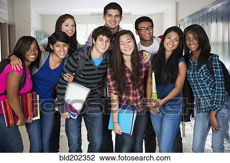 Stock Image - High school friends standing in corridor together. Fotosearch