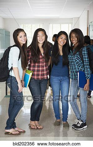 Stock Photograph - High school friends standing in corridor together. Fotosearch