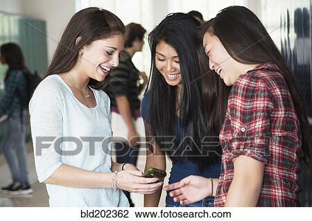 High school students looking at cell phone together View Large Photo Image Stock Image - High school students looking at cell phone together. Fotosearch