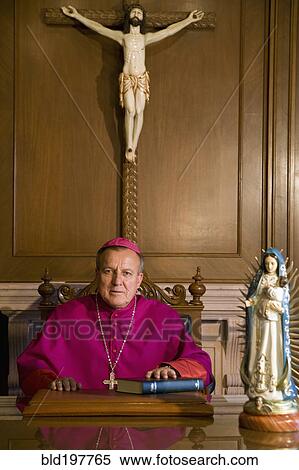 Stock Photography - Hispanic bishop sitting with bible. Fotosearch