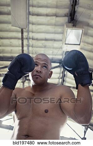 Stock Image - Hispanic boxer training in gym. Fotosearch