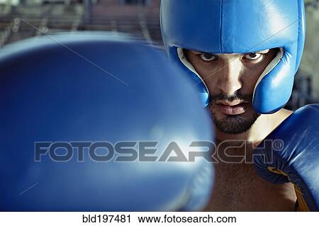 Stock Image - Hispanic boxer training in gym. Fotosearch