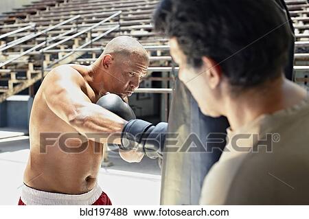 Stock Photo - Hispanic boxer training in gym. Fotosearch
