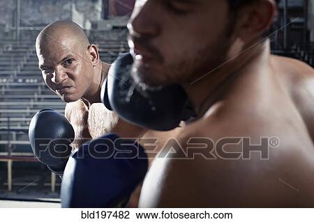 Stock Image - Hispanic boxers sparring in gym. Fotosearch