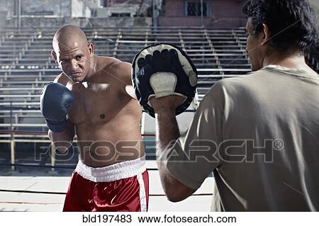 Stock Image - Hispanic boxers sparring in gym. Fotosearch