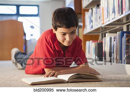 Hispanic boy reading book in library View Large Photo Image Stock Photography - Hispanic boy reading book in library. Fotosearch