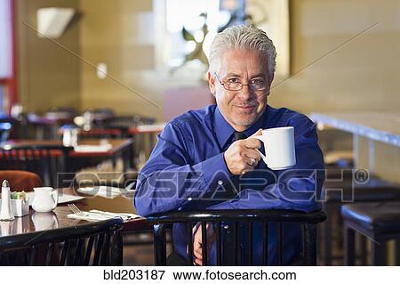 Hispanic cafe owner having cup of coffee View Large Photo Image Stock Photo - Hispanic cafe owner having cup of coffee. Fotosearch