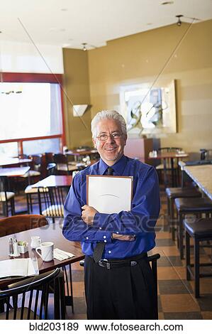 Hispanic cafe owner holding clipboard View Large Photo Image Stock Photo - Hispanic cafe owner holding clipboard. Fotosearch