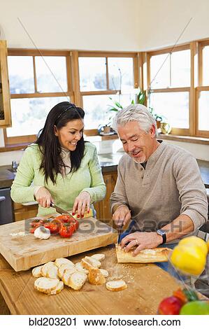 Hispanic couple cooking together in kitchen View Large Photo Image Stock Image - Hispanic couple cooking together in kitchen. Fotosearch