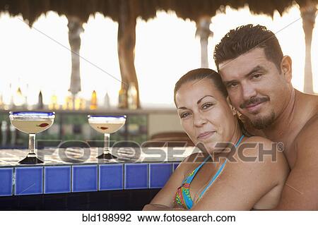 Stock Image - Hispanic couple drinking cocktails. Fotosearch