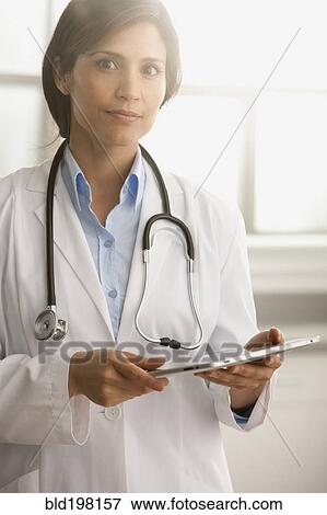 Hispanic doctor using digital tablet View Large Photo Image Stock Photo - Hispanic doctor using digital tablet. Fotosearch