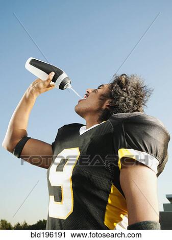 Hispanic football player drinking water View Large Photo Image Stock Image - Hispanic football player drinking water. Fotosearch