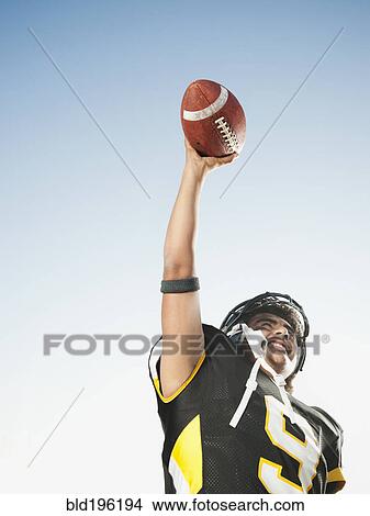 Hispanic football player lifting football View Large Photo Image Picture - Hispanic football player lifting football. Fotosearch