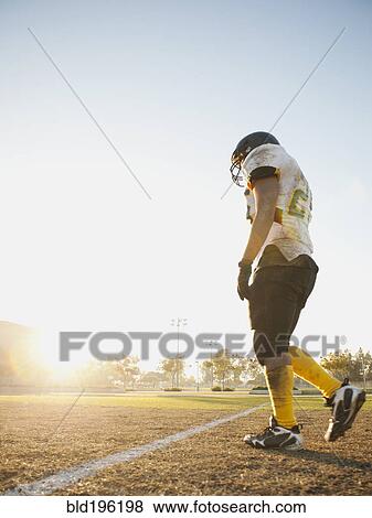 Hispanic football player walking on football field View Large Photo Image Stock Photo - Hispanic football player walking on football field. Fotosearch