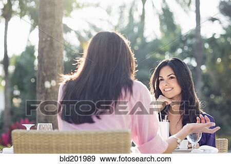 Stock Photo - Hispanic friends having lunch together. Fotosearch