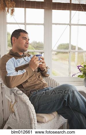 Stock Image - Hispanic man relaxing and drinking coffee. Fotosearch