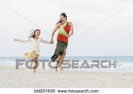 Hispanic mother and daughter running on beach View Large Photo Image Stock Photo - Hispanic mother and daughter running on beach. Fotosearch