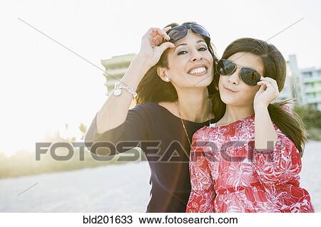 Stock Image - Hispanic mother and daughter wearing sunglasses. Fotosearch