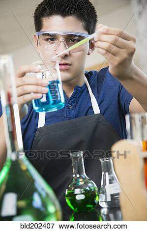Stock Photo - Hispanic student working with chemicals in classroom. Fotosearch