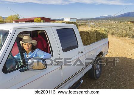 Stock Image - Hispanic woman driving truck. Fotosearch