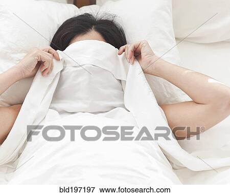 Hispanic woman in bed covering her face View Large Photo Image Stock Photo - Hispanic woman in bed covering her face. Fotosearch