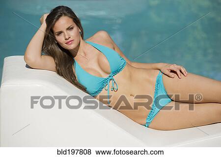Hispanic woman in bikini laying near swimming pool View Large Photo Image Stock Photo - Hispanic woman in bikini laying near swimming pool. Fotosearch