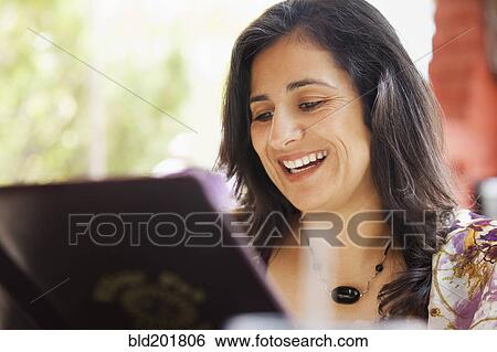 Hispanic woman looking at restaurant menu View Large Photo Image Stock Photograph - Hispanic woman looking at restaurant menu. Fotosearch