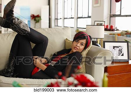 Hispanic woman relaxing on sofa in living room View Large Photo Image Stock Image - Hispanic woman relaxing on sofa in living room. Fotosearch
