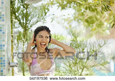 Stock Photograph - Hispanic woman showering outdoors. Fotosearch