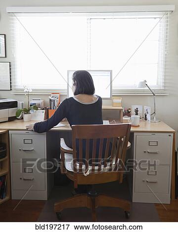 Stock Photo - Hispanic woman working in home office. Fotosearch