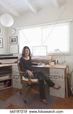 Hispanic woman working in home office View Large Photo Image Stock Photo - Hispanic woman working in home office. Fotosearch