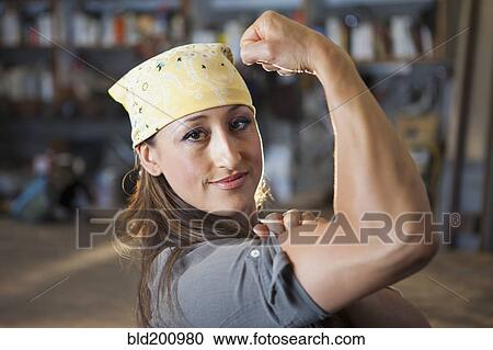 Stock Image - Hispanic worker flexing biceps. Fotosearch