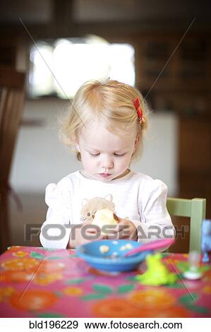Stock Photo - Hungry Caucasian girl eating food. Fotosearch