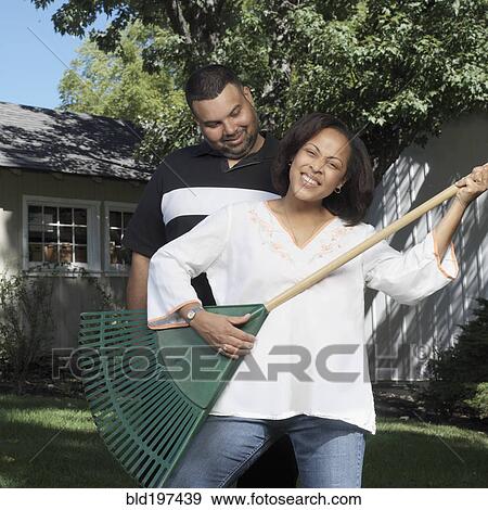 Husband watching woman playing air guitar with rake View Large Photo Image Stock Photo - Husband watching woman playing air guitar with rake. Fotosearch
