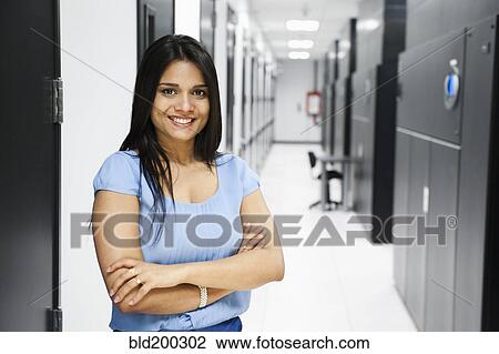 Stock Image - Indian businesswoman standing in server room. Fotosearch