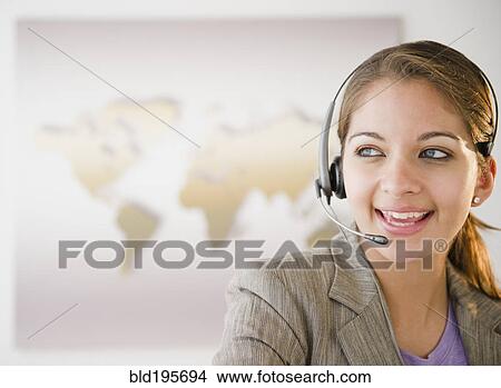 Indian businesswoman talking on headset in office View Large Photo Image Picture - Indian businesswoman talking on headset in office. Fotosearch
