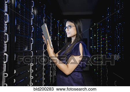 Stock Image - Indian businesswoman working in server room. Fotosearch