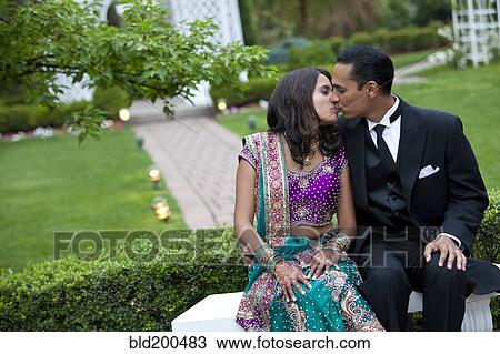 Stock Image - Indian couple in traditional clothing kissing. Fotosearch