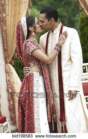Indian couple in traditional wedding clothing, kissing View Large Photo Image Stock Image - Indian couple in traditional wedding clothing, kissing. Fotosearch